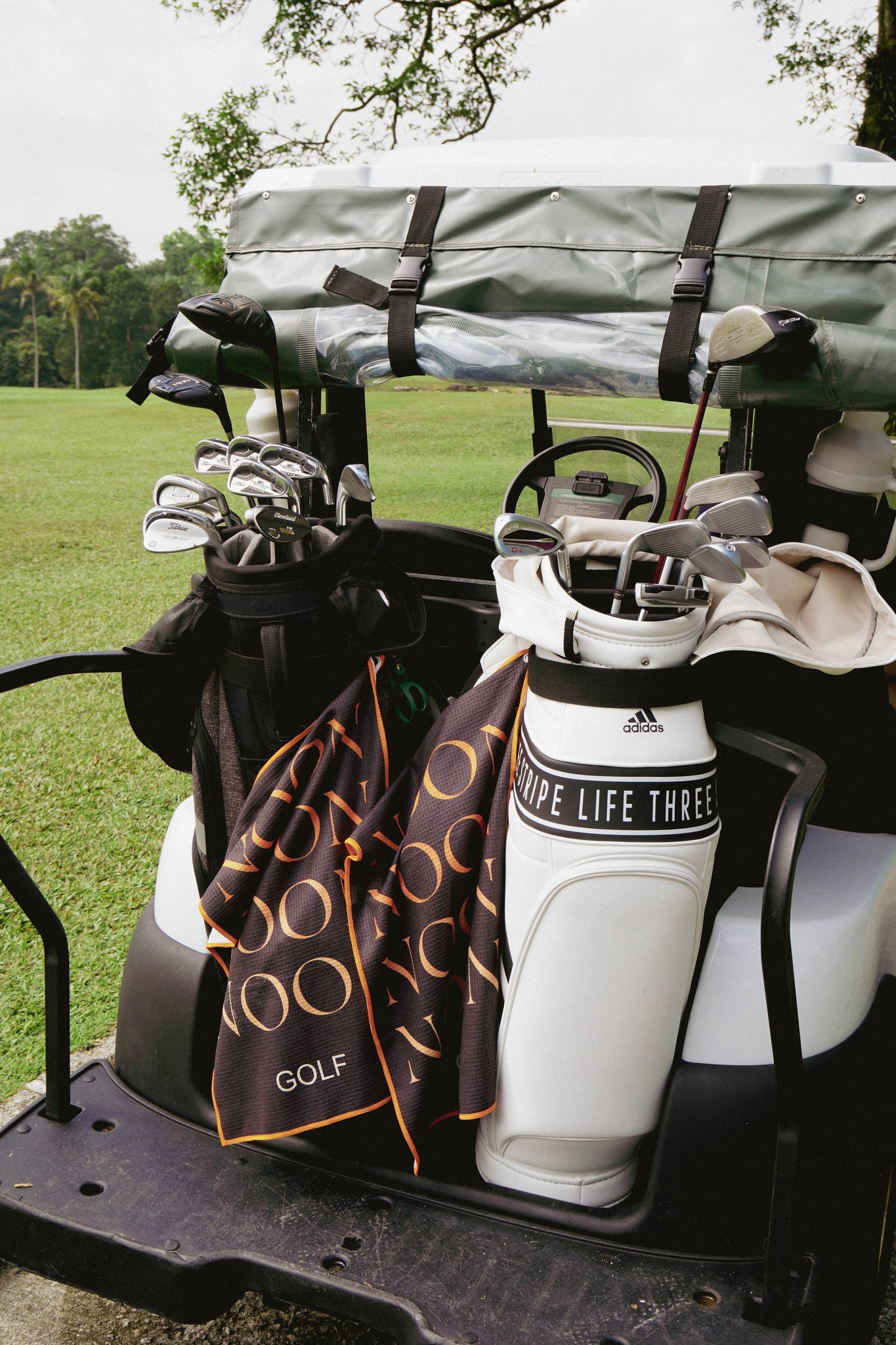 Noon golf towel attached to a golf bag on the back of a golf buggy