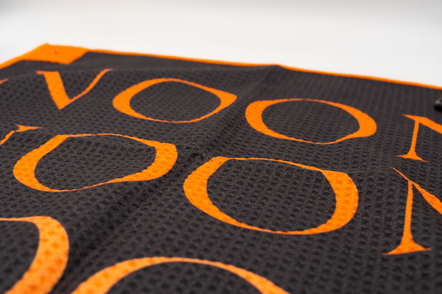 Close up of golf towel with Noon brand logo