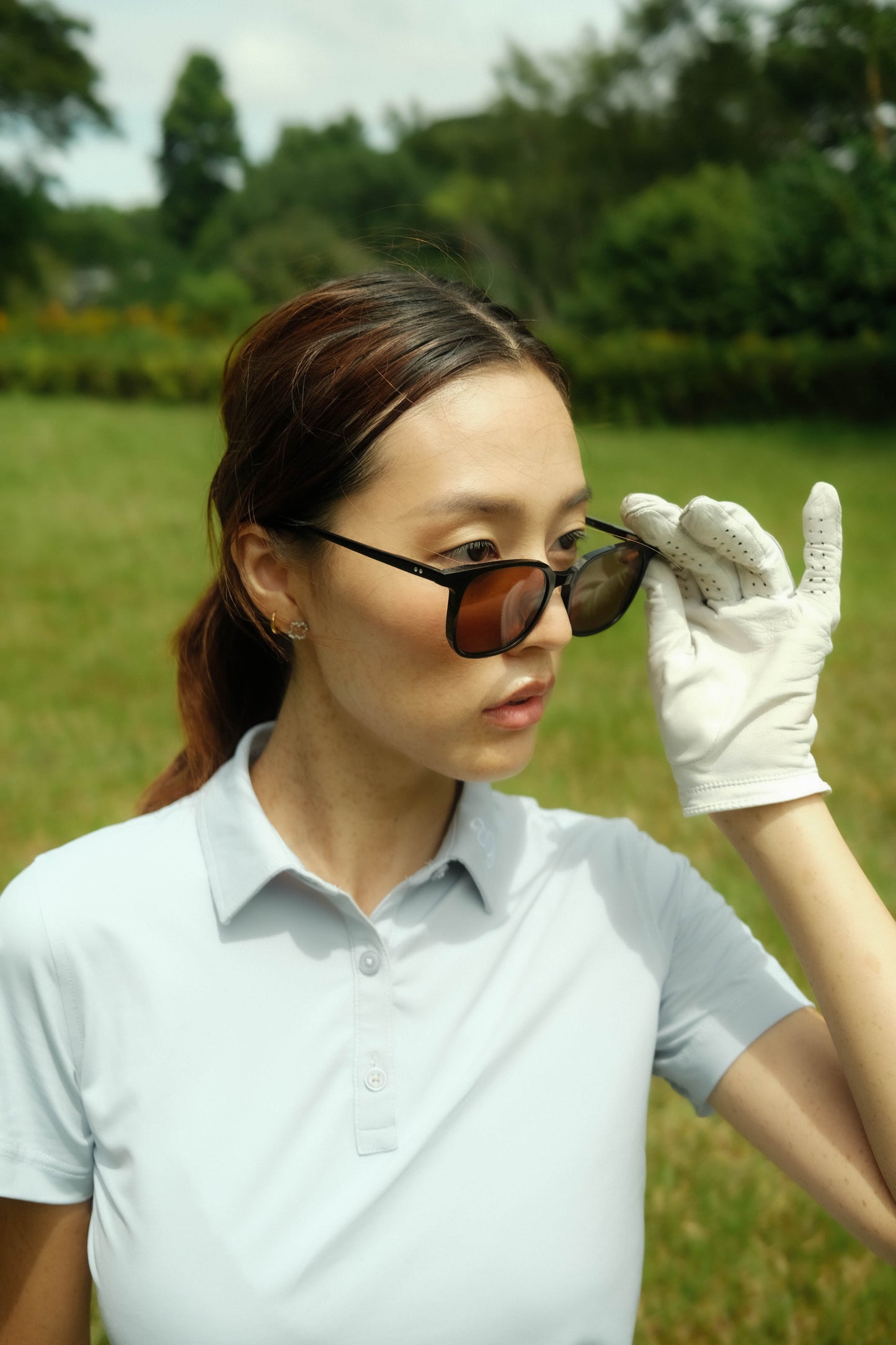 Female golfer wearing paxton golf sunglasses in black